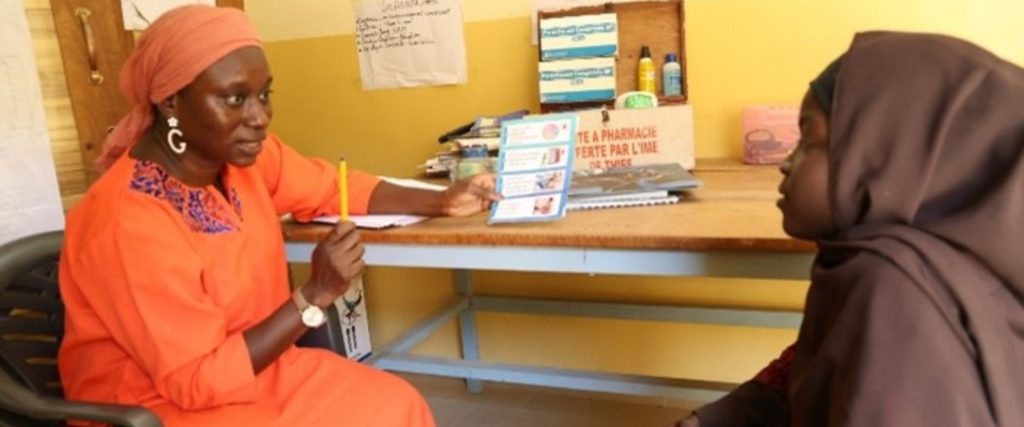 Joséphine, enseignante en charge des activités de SRM du projet PASSAJE, parle à Zainab de l'utilisation des serviettes hygiéniques et des bonnes pratiques d'hygiène menstruelle.