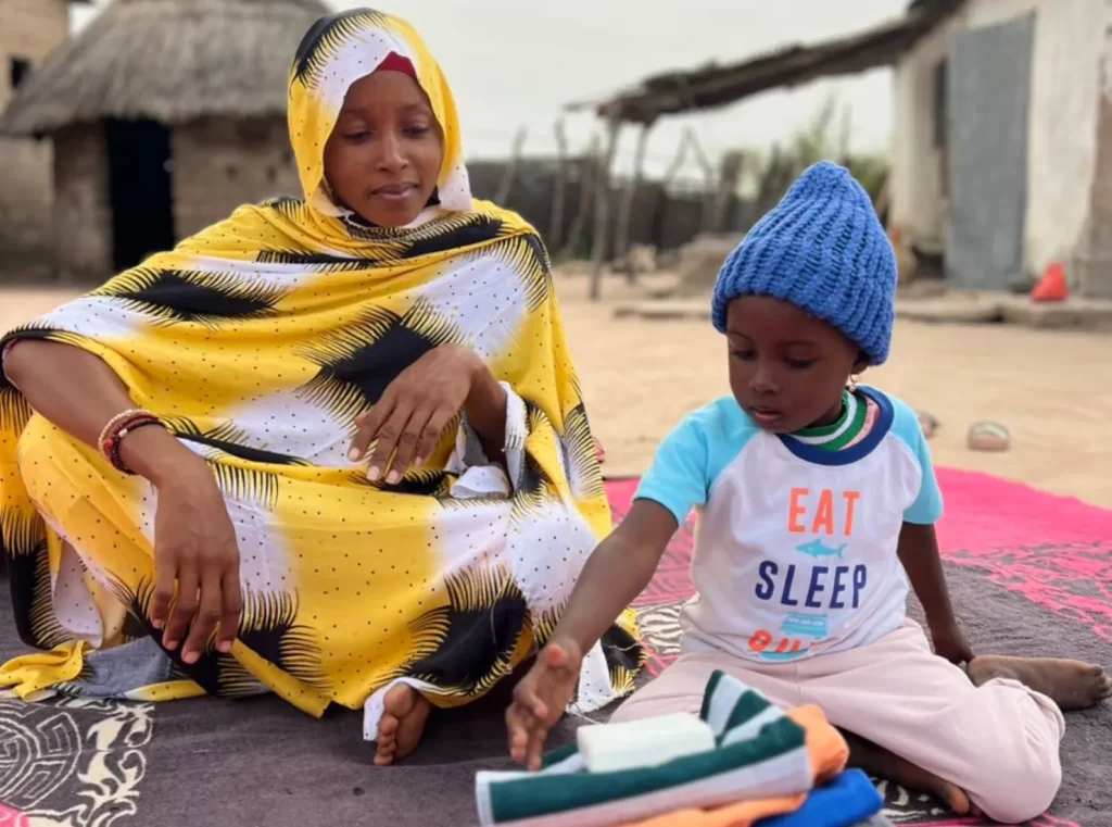 La petite Sokhna Fatimatou, 3 ans, prend soin des articles de son kit bébé offert par ChildFund.