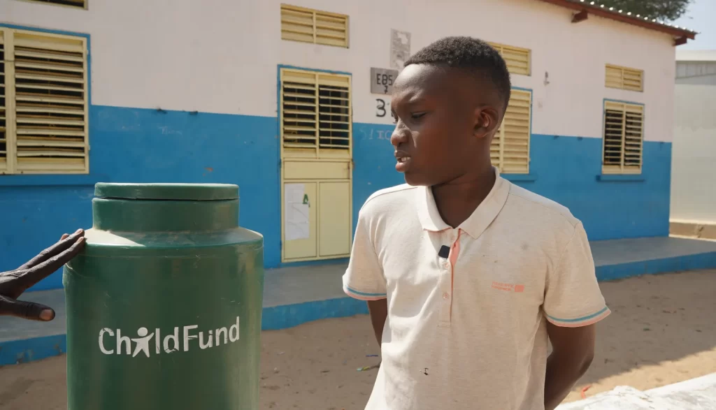 Le jeune Mountakha explique l’importance de la station de lavage des mains pour maintenir une bonne hygiène à l’école