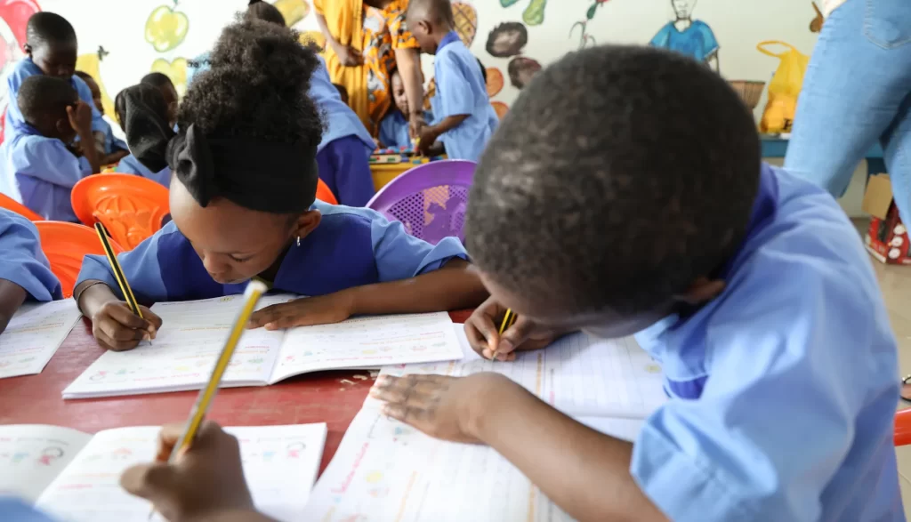 Un groupe d’enfants de la maternelle concentré sur leurs exercices d'écriture